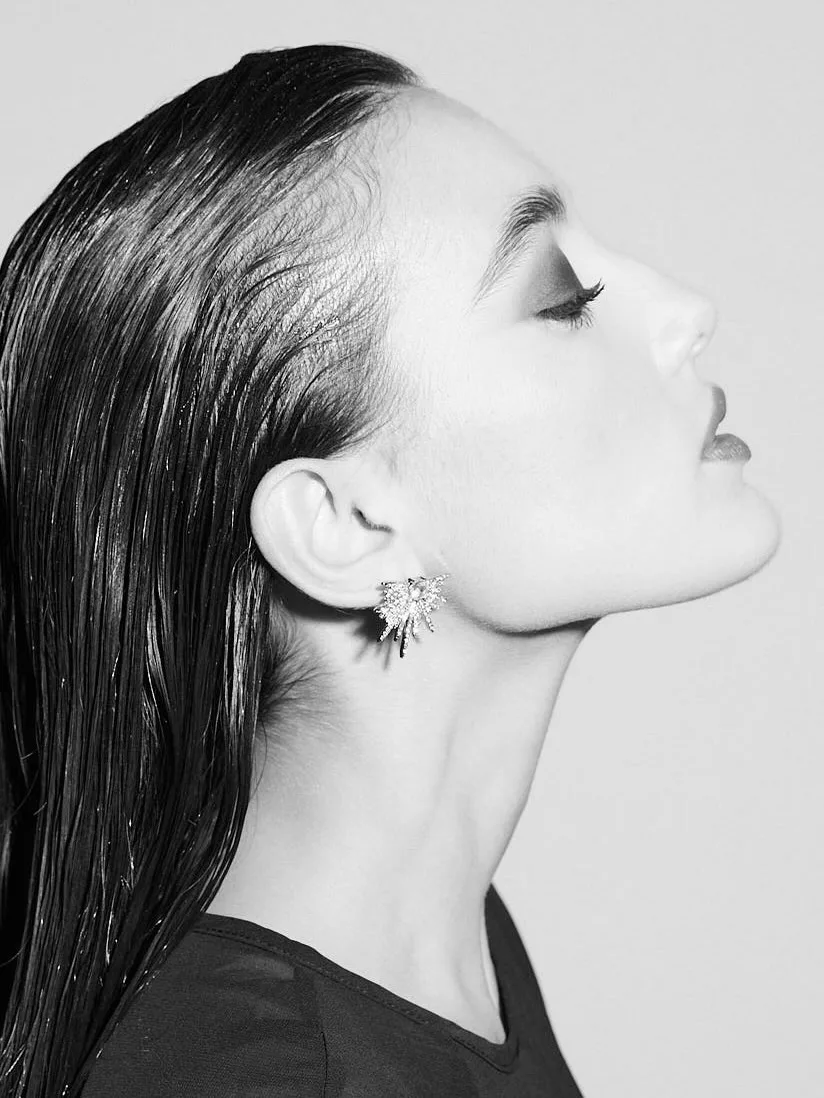 A black and white profile of Zeudi with closed eyes and her face tilted toward the light.