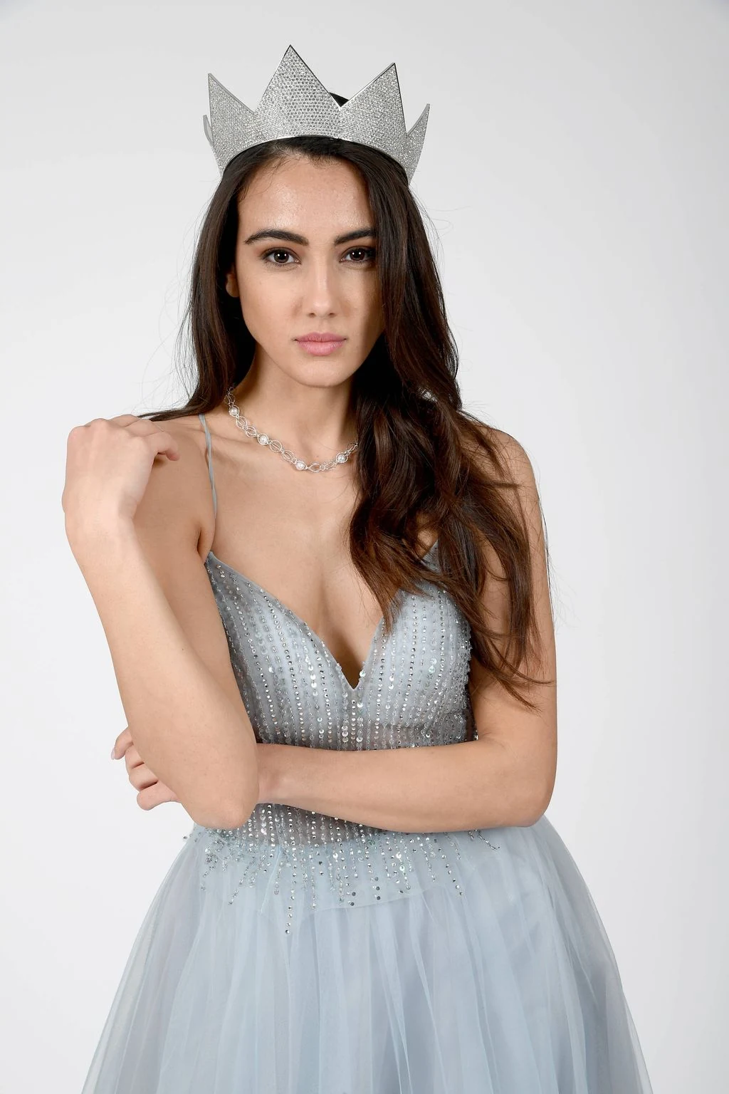 Zeudi Di Palma wearing her Miss Italia crown and a pale silver-blue embellished gown, posed against a light background.